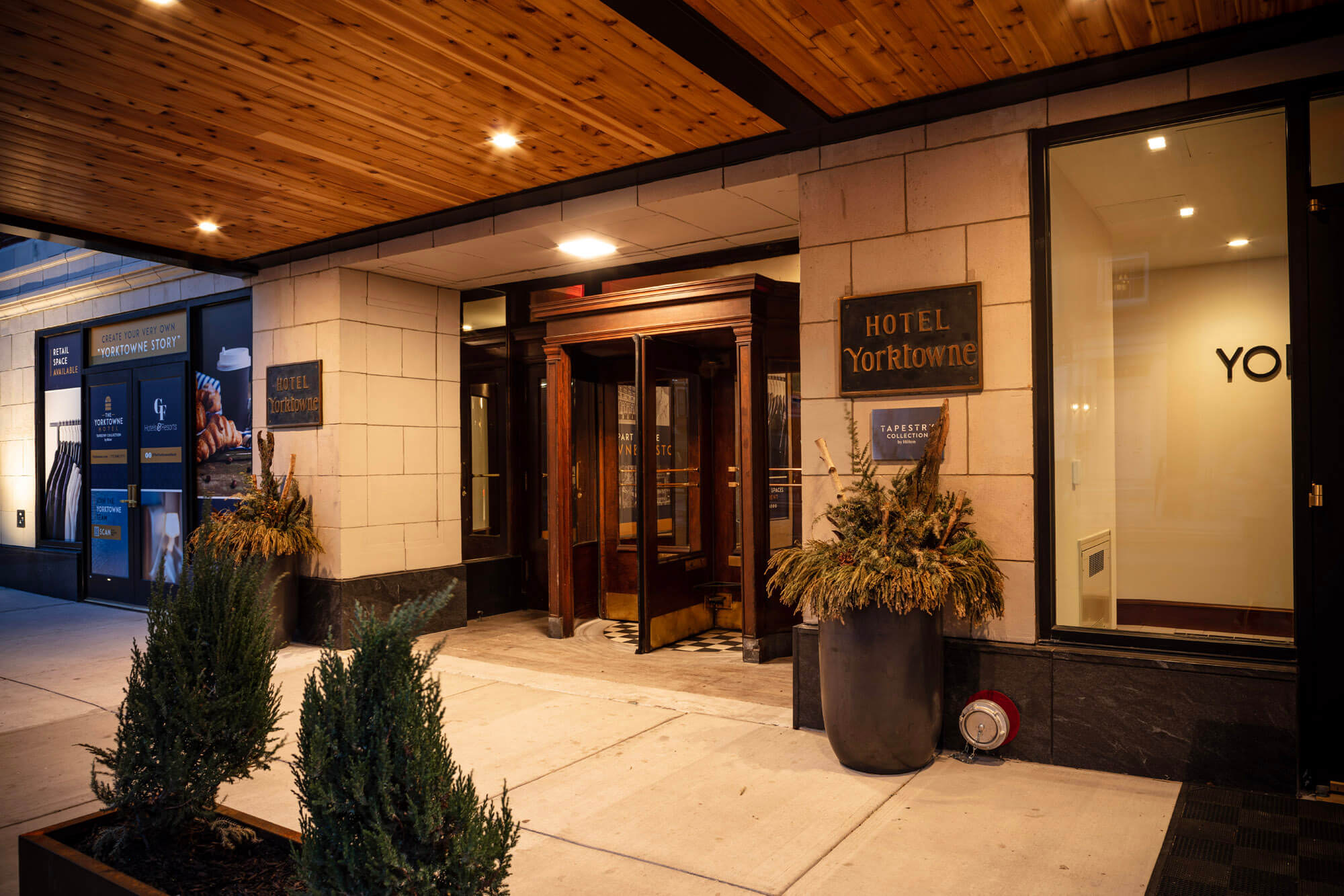 The front entrance tot he hotel with the old wooden doors and name plate next to the door.