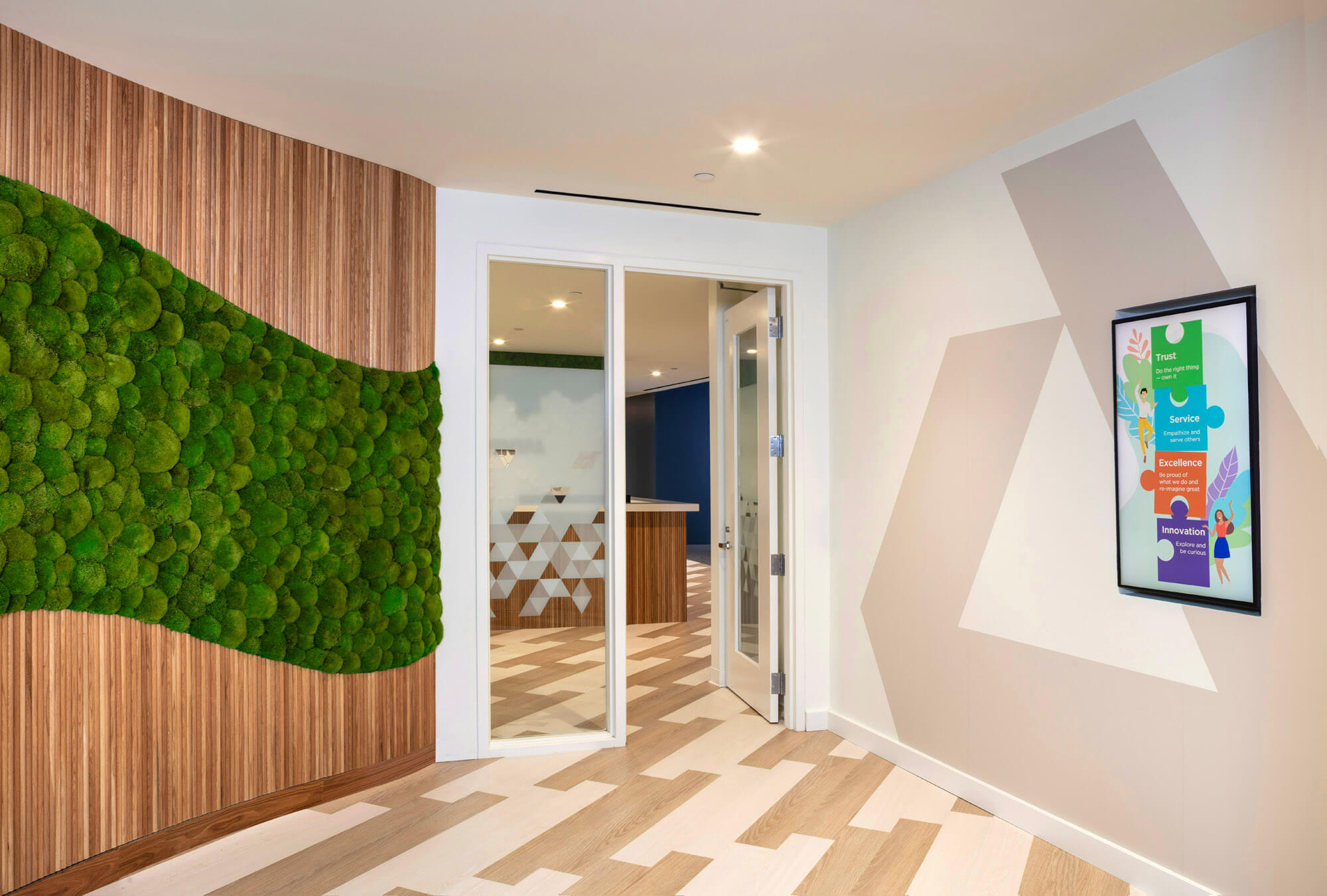 Image looking down a hallway with a door and wooden floors. There is moss on the wall.