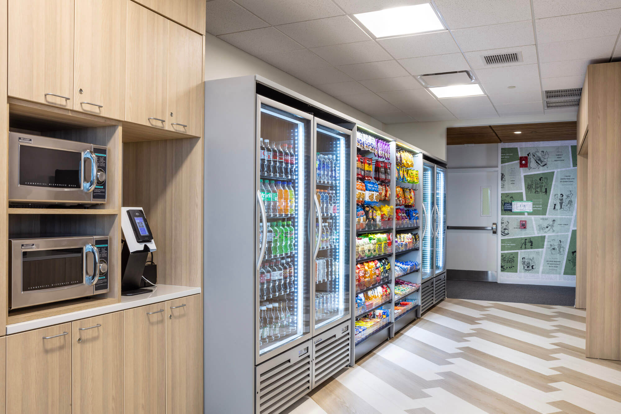 The snack machine and microwave area with snack machines loaded with chips and drinks.