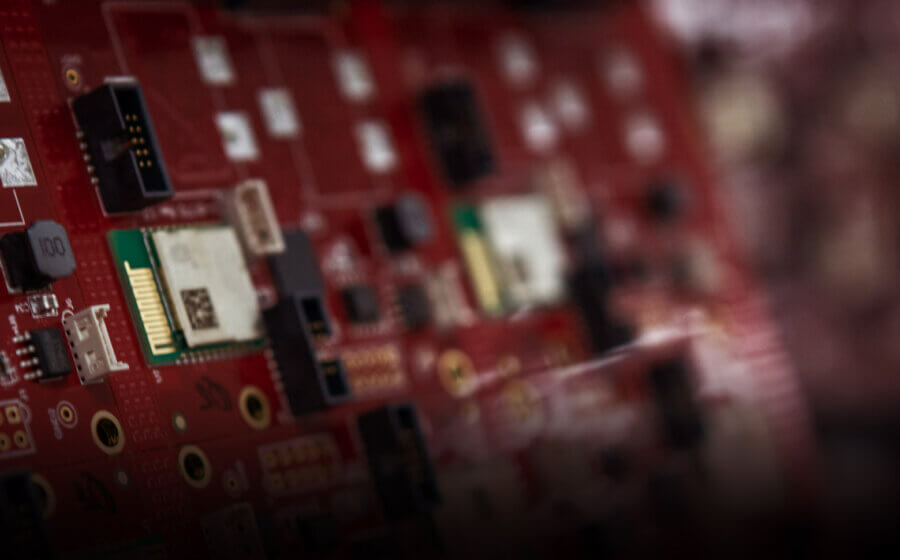 Close up image of a red circuit board with a blurred background.