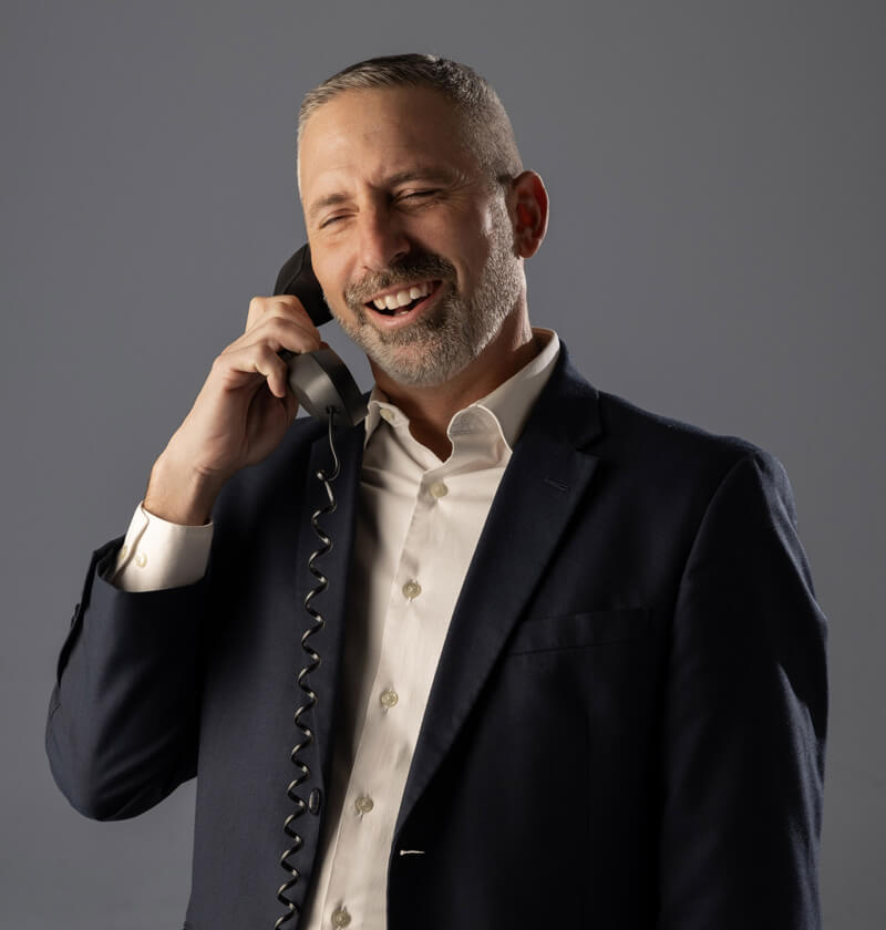 Man in a sports coat talking on a phone