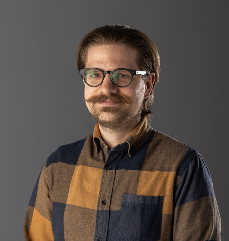 A man in a plaid shirt looking at the camera.