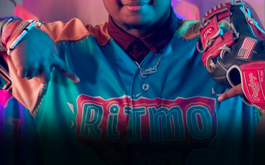 Baseball player wearing the RiTmo de York baseball shirt and holding a baseball glove.