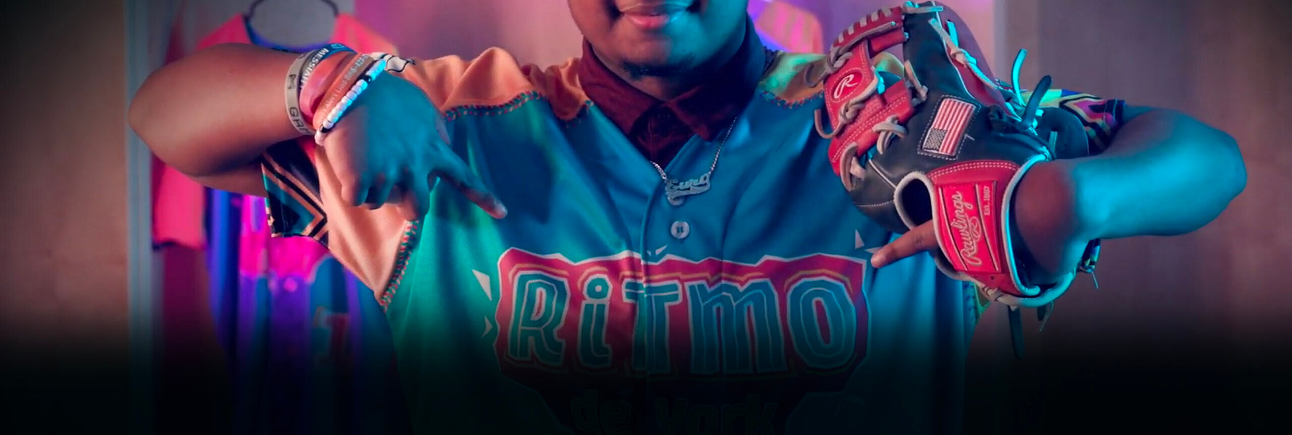 Baseball player wearing the RiTmo de York baseball shirt and holding a baseball glove.