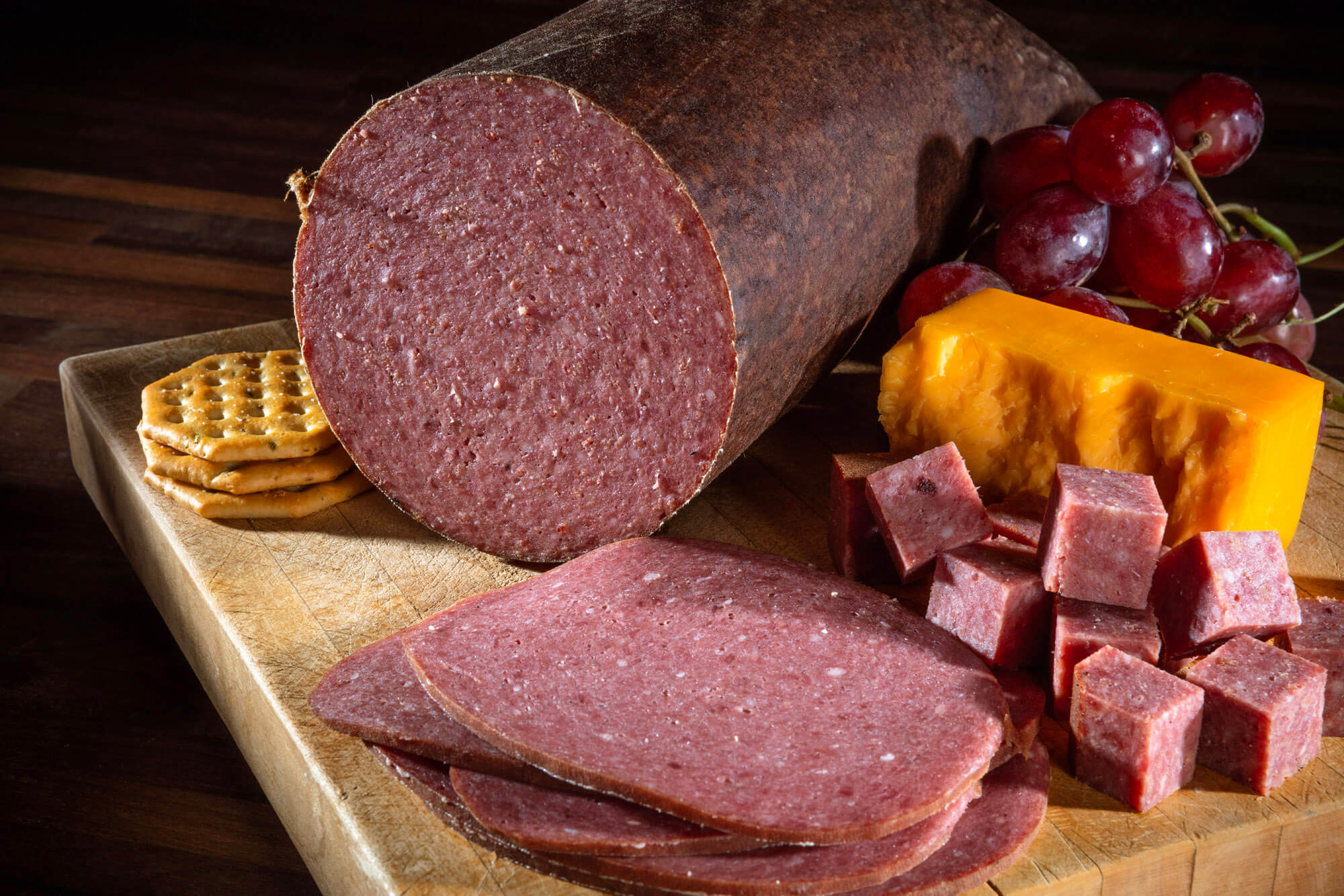 Bologna slices on a board with chees and biscuits