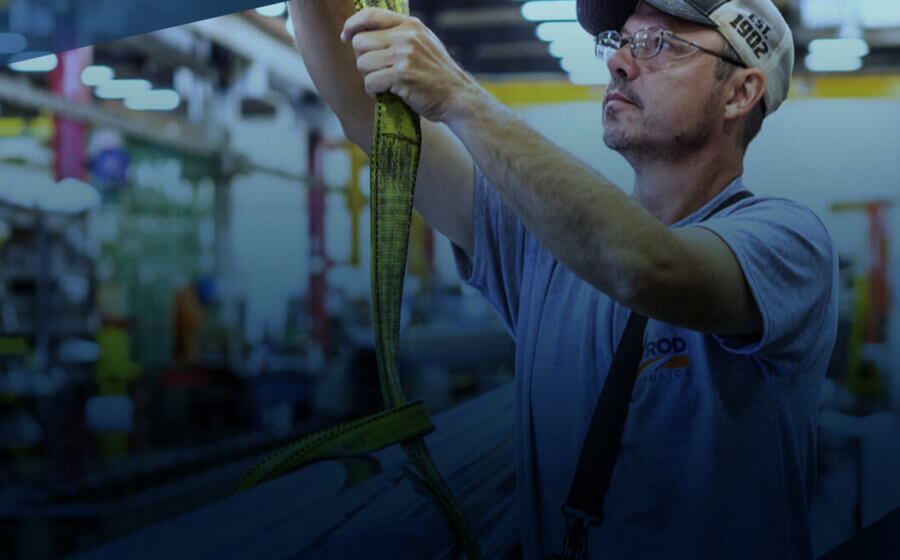 A man in the Garrod factory pulling on a yellow rope connected to a cylinder.