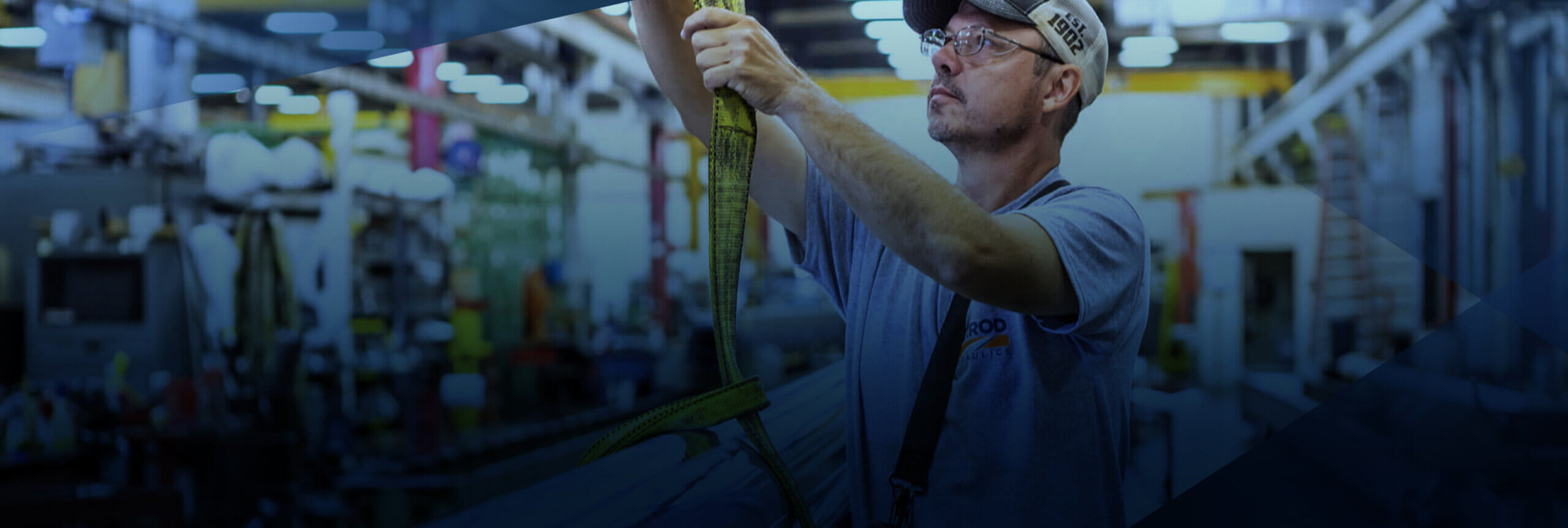 A man in the Garrod factory pulling on a yellow rope connected to a cylinder.