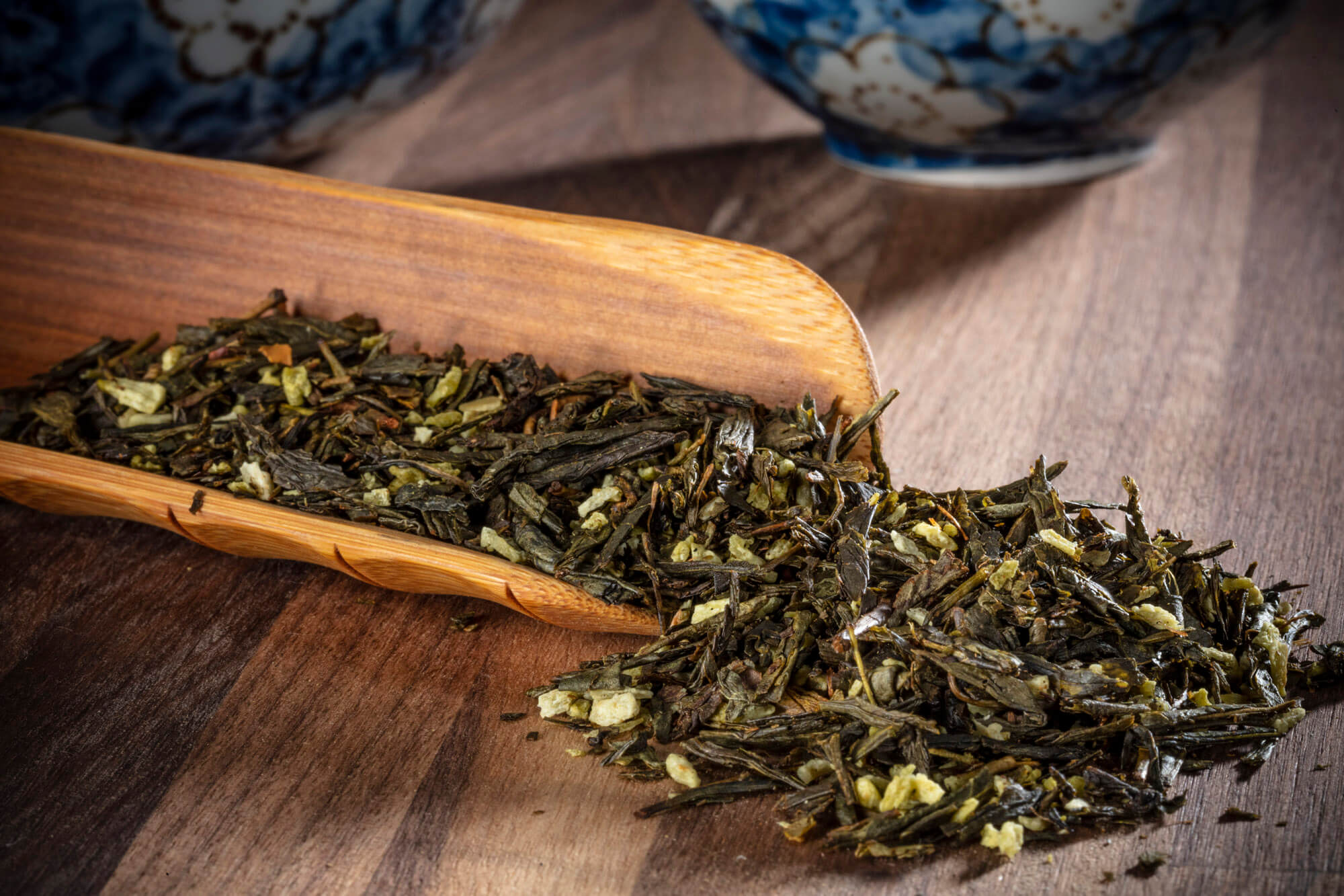 Loose tea leaves scattered on a wooden board.