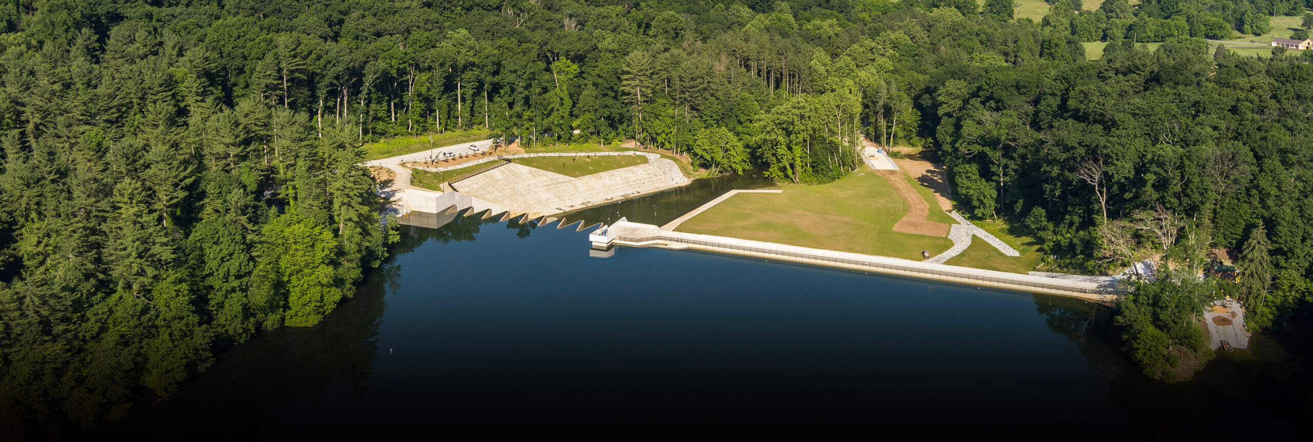 A drone shot of the Lake with a dam.