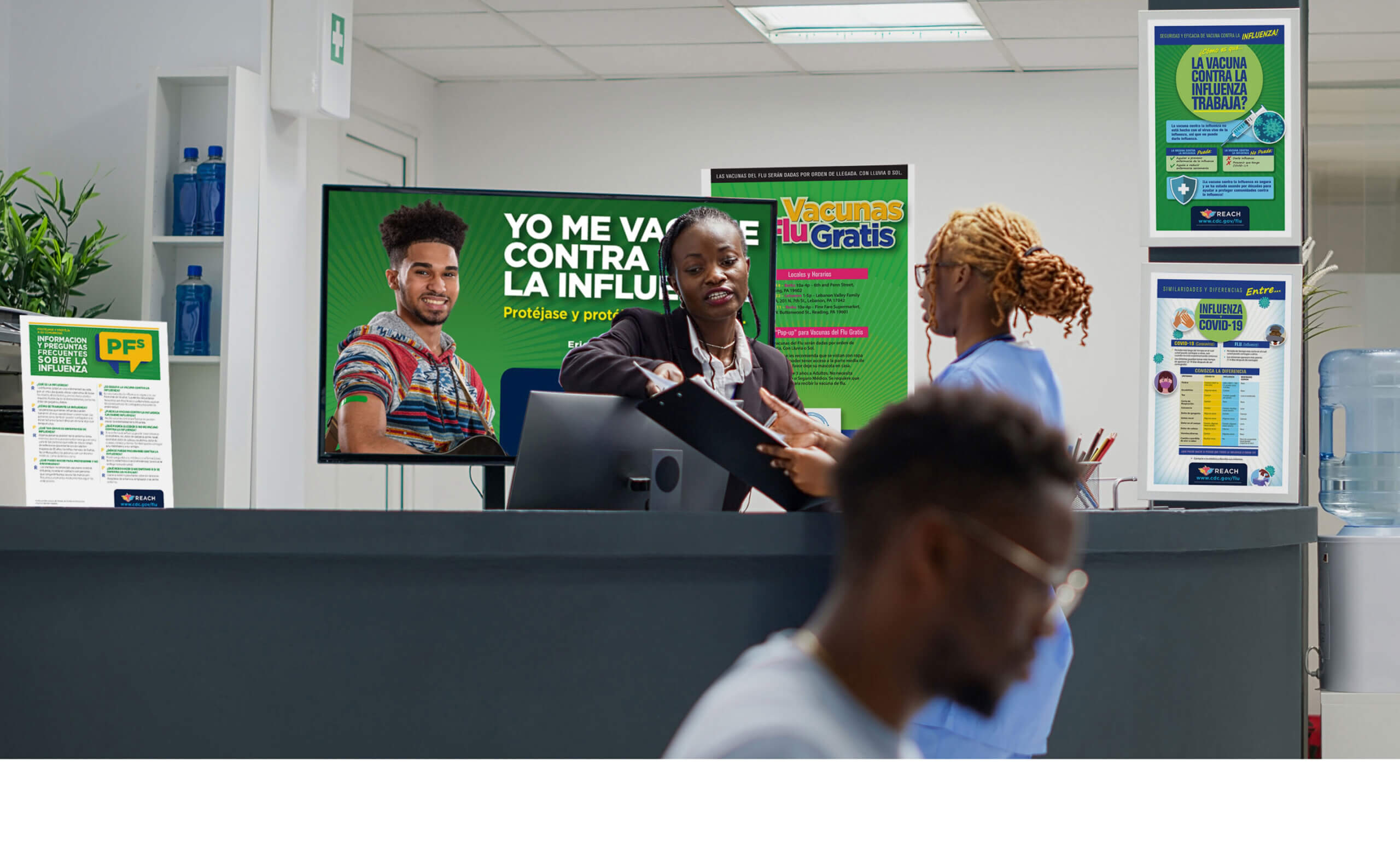 A reception desk with REACH flu campaign advertising displayed behind the desk