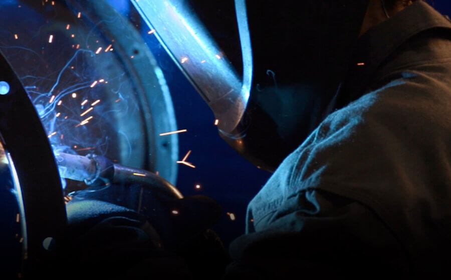 A close-up shot of a person in a welding helmet doing welding.