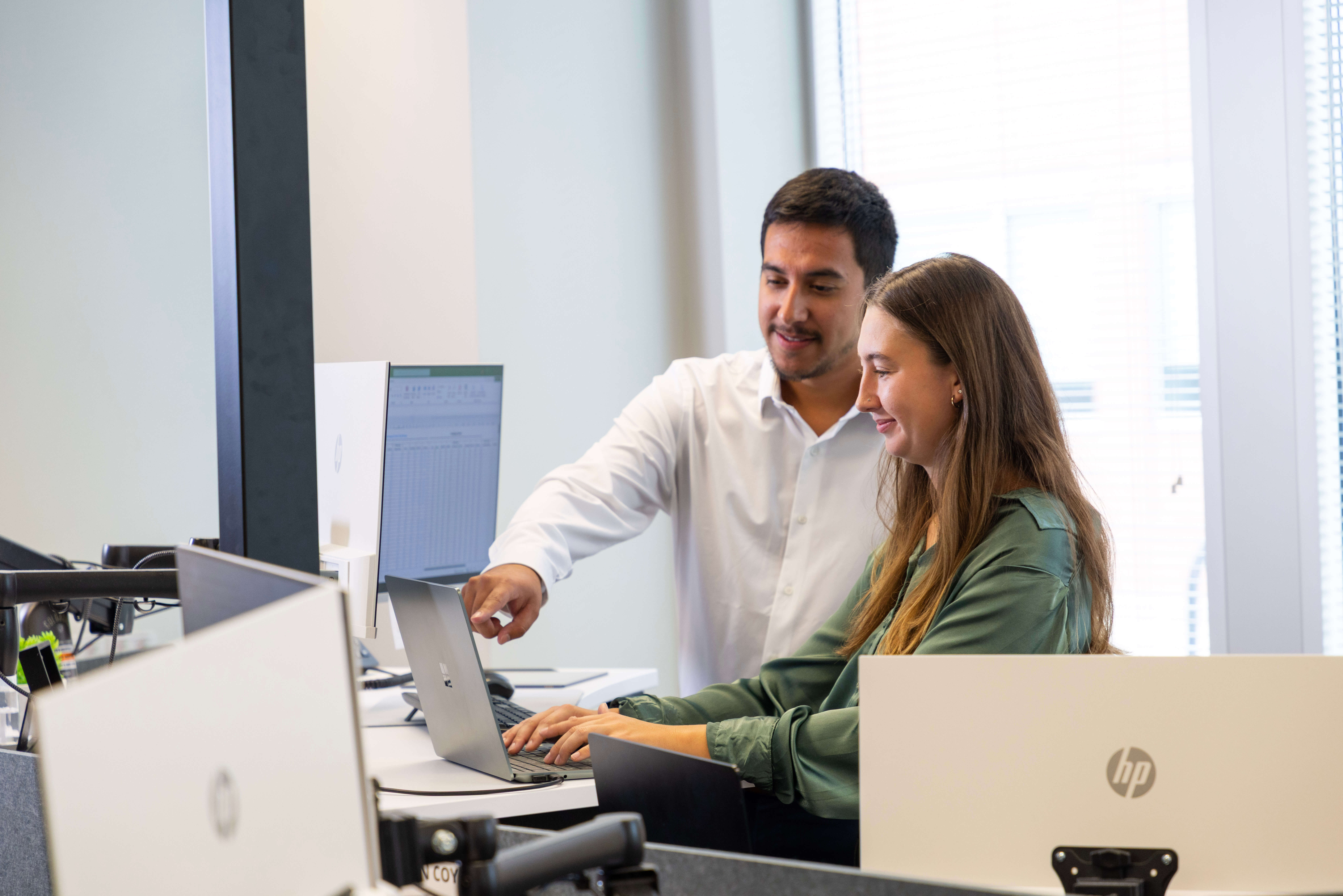 Man and woman at work looking at computer monitors.