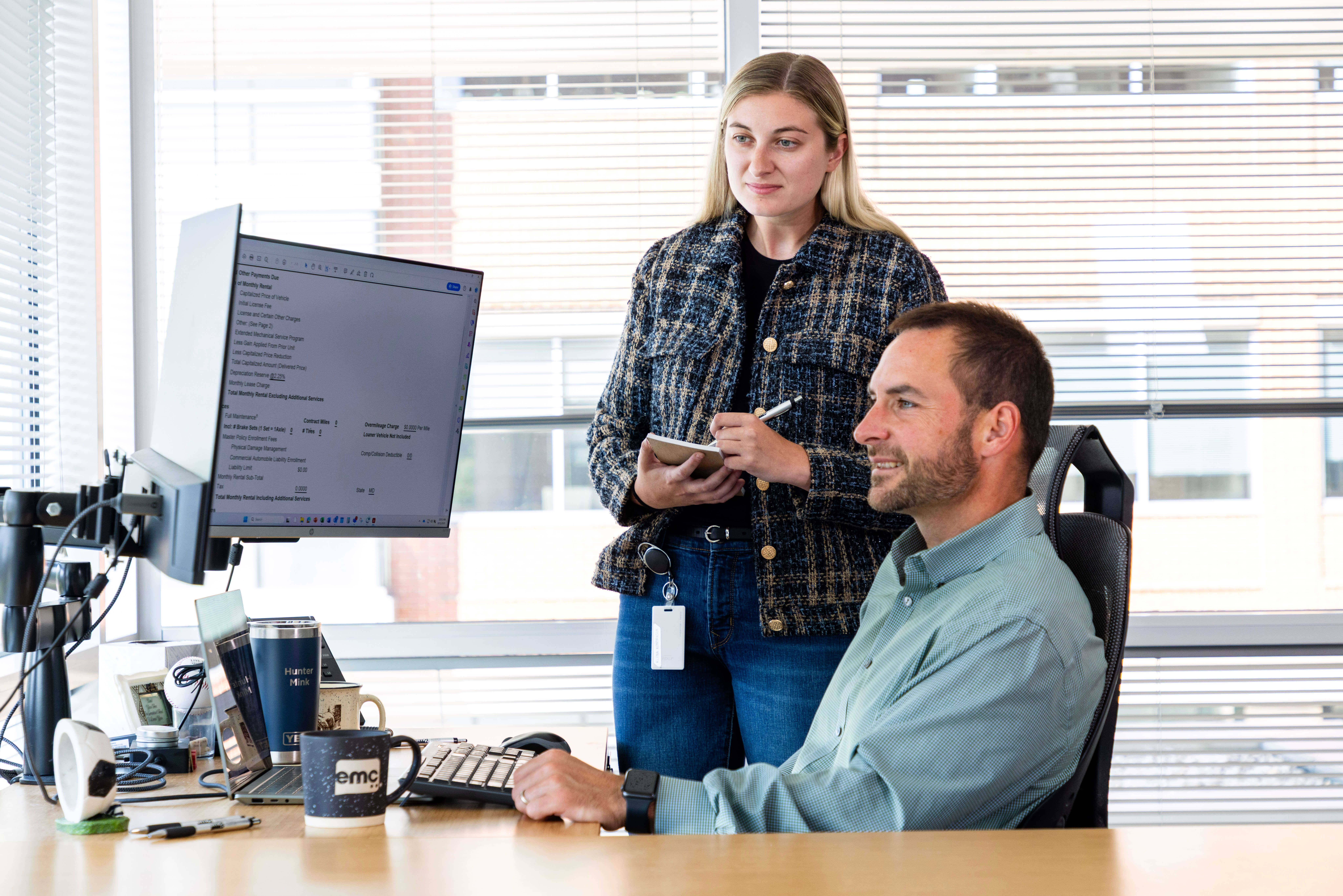 A woman and man at work looking at computer monitors.