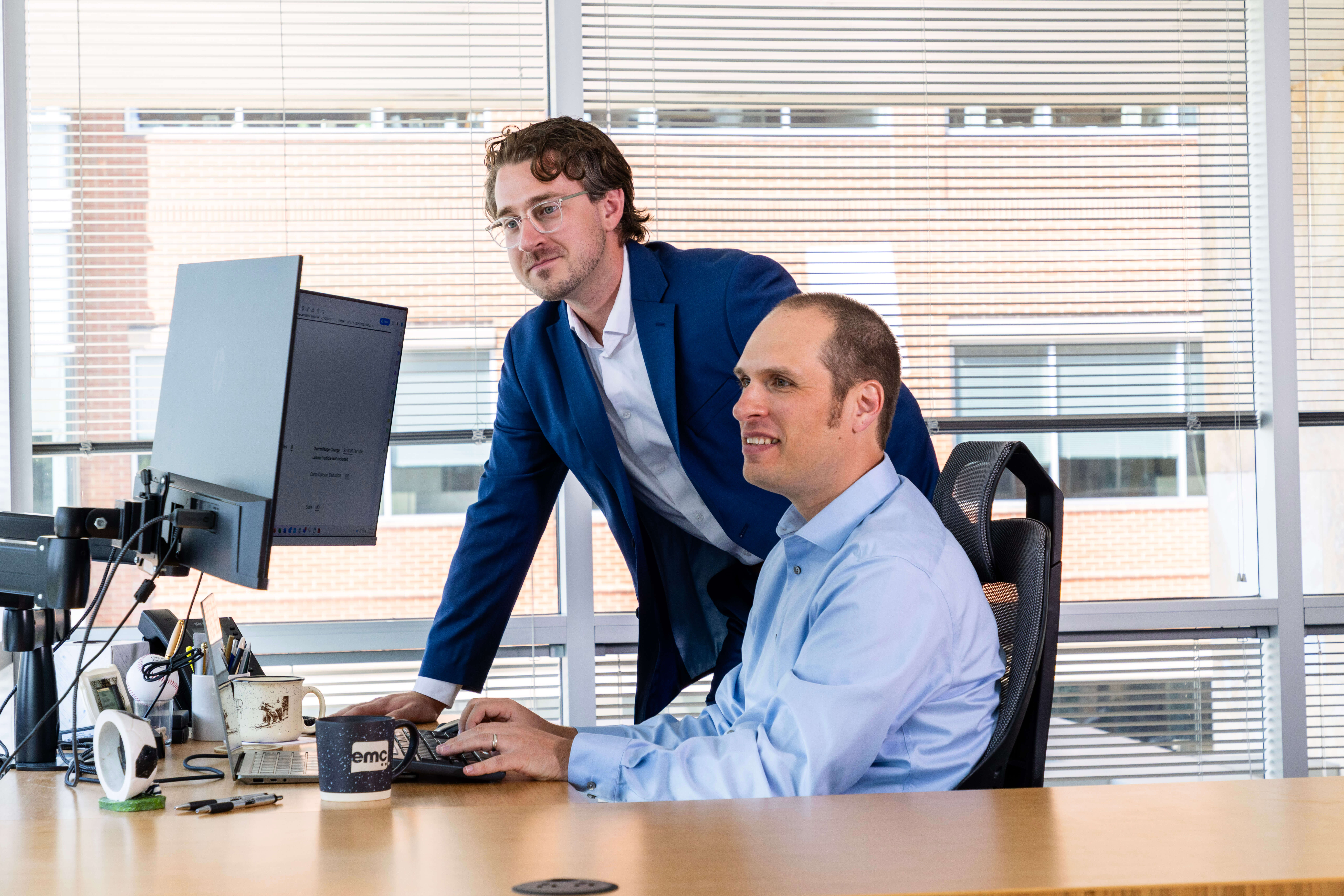Two men at work looking at computer monitors.